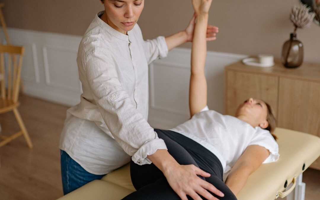 Physical therapist guiding a patient through a hip and shoulder exercise on a treatment table